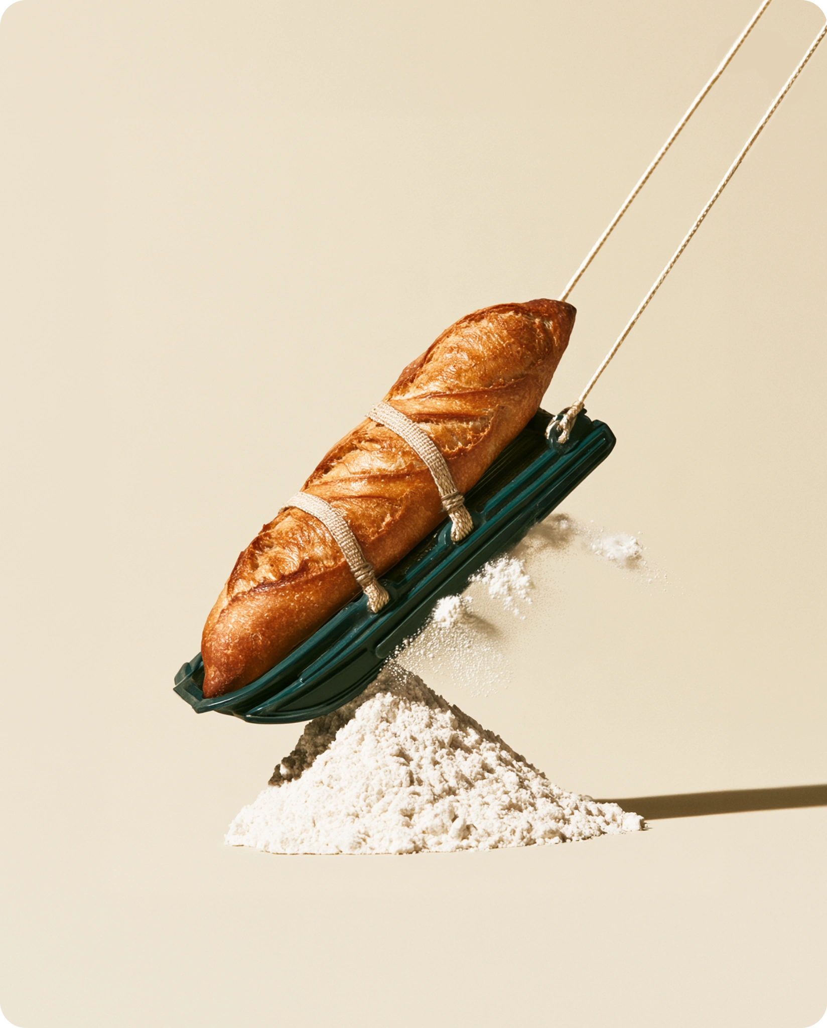 Une baguette en luge sur une vague de farine.